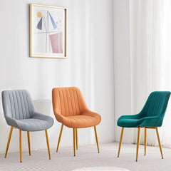 Its channel-back shape, plush cushioning, and waterfall seat design elevate daily dining, while the gold-tipped metal legs add visual lightness.