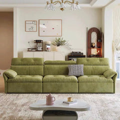Green sofa in a living room with a coffee table and decor items.