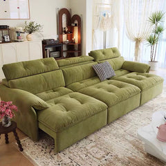 Green sectional sofa in a living room with decorative elements.