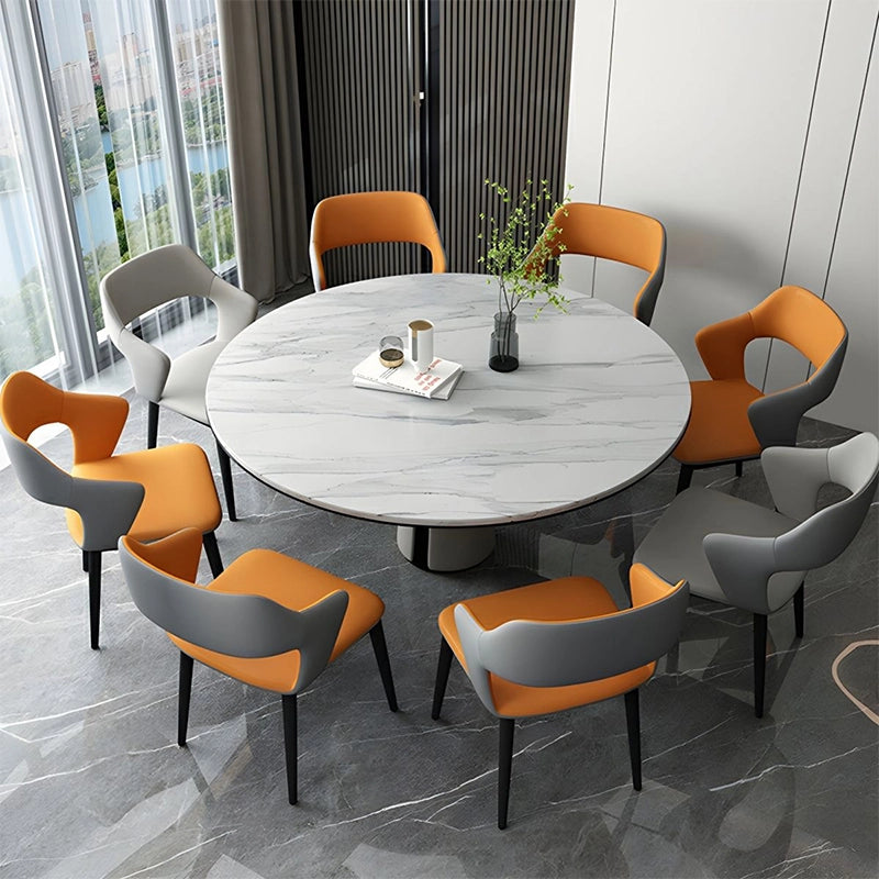 The Aura dining chair features a sleek curved backrest, integrated arm contours, and a distinctive waterfall seat front, blending ergonomic comfort with visual elegance.