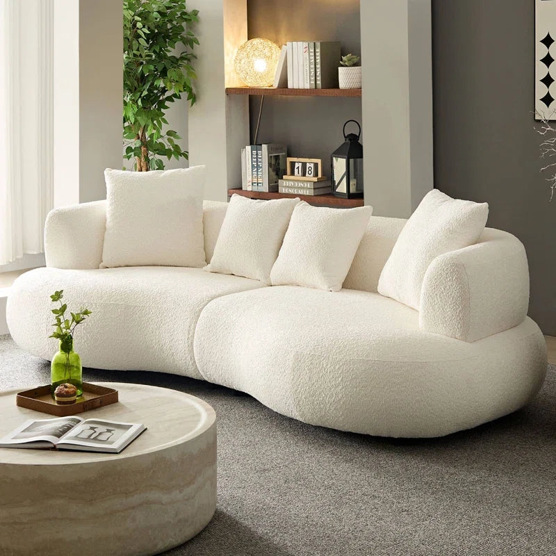 Hidden legs maintain a sculptural silhouette, while the cushioned back and rounded arms add softness and support. 