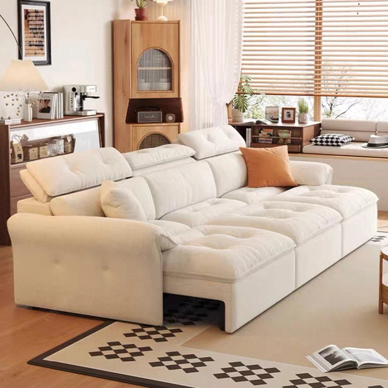 White sectional sofa in a living room with wooden furniture and decor.