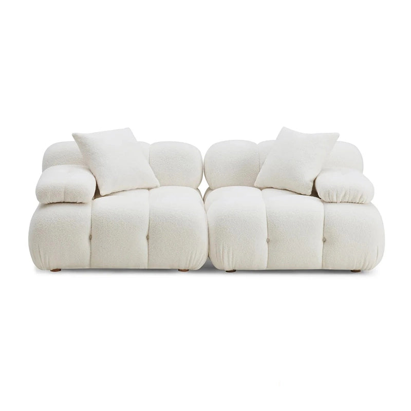 White sofa with multiple cushions on a white background
