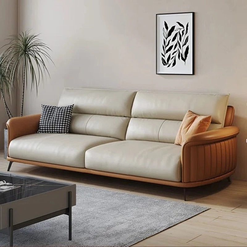 Modern living room with a beige and brown sofa, coffee table, and decorative elements.