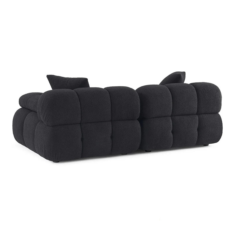 This contemporary sofa design features deeply tufted cushions, pillow-like armrests, and soft rounded edges that define both comfort and style. 