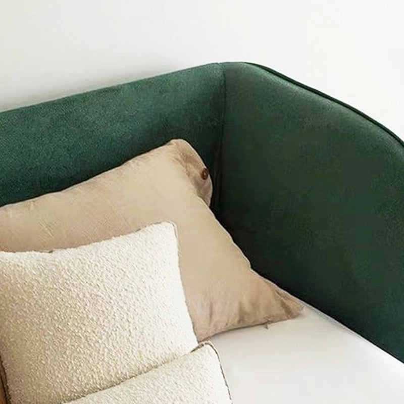 It features a thick wrap-around headboard and a fully padded frame, offering cocoon-like comfort in either a deep forest green or soft beige matte fabric.