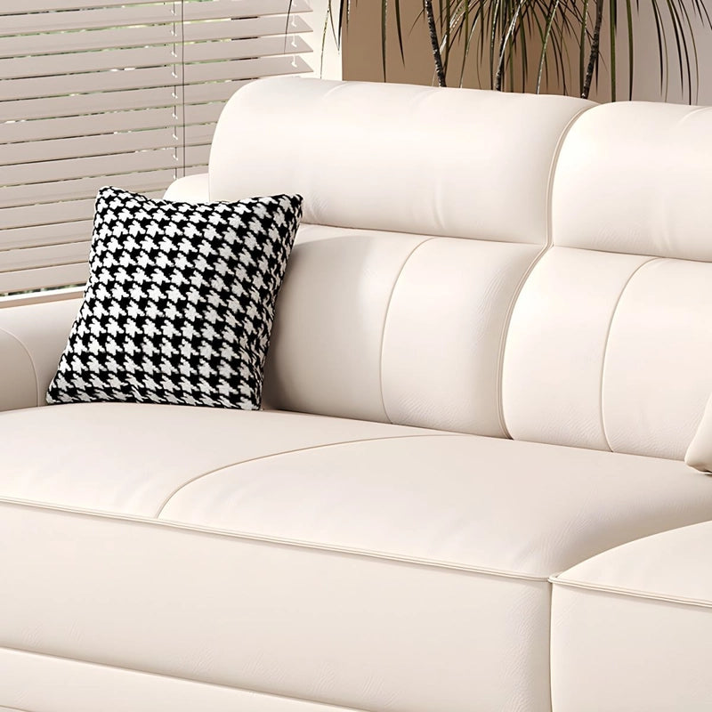 White sofa with a black and white patterned pillow against a neutral background