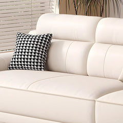 White sofa with a black and white patterned pillow against a neutral background