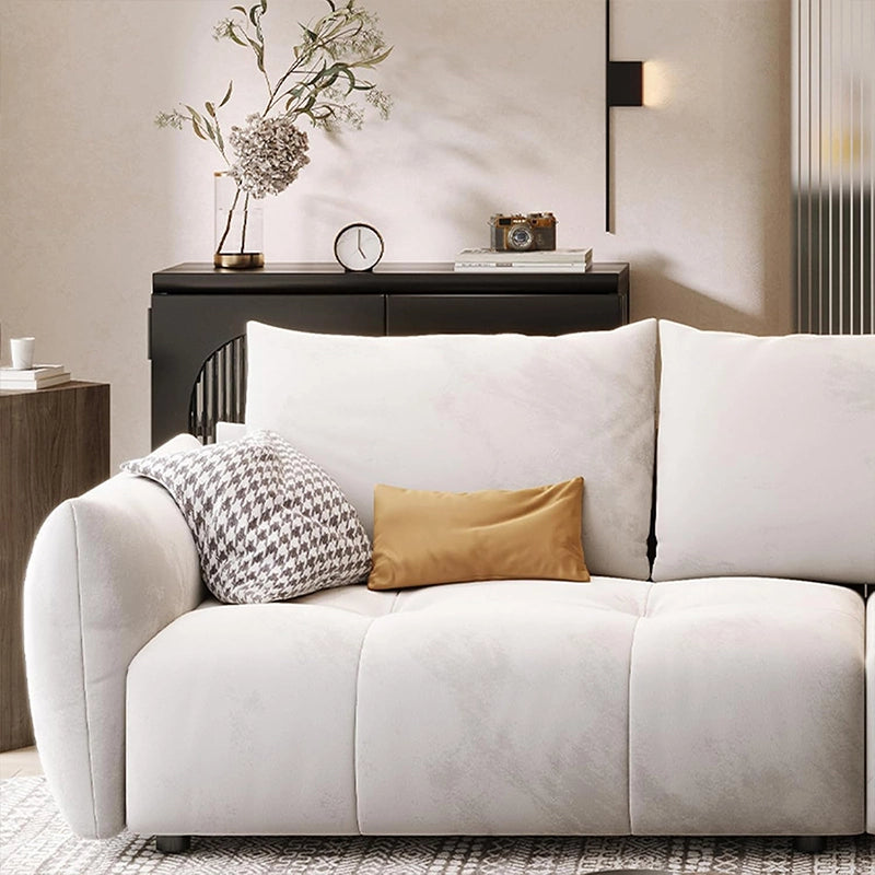 This modern fabric sofa features soft ivory upholstery, deep seating, and rounded arms that blend comfort with contemporary flair.