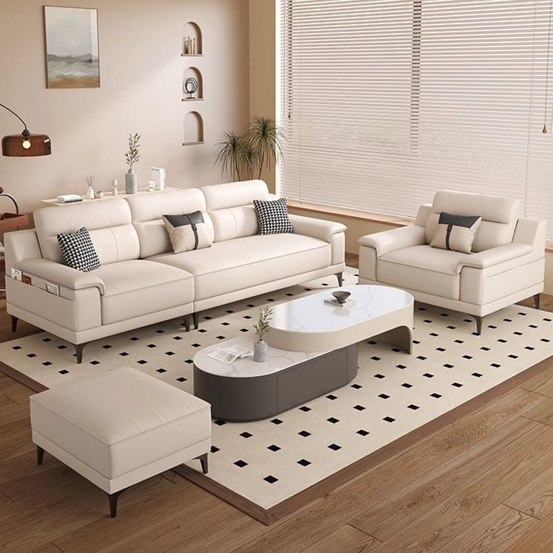 Modern living room with beige sectional sofa, armchair, and coffee table on a patterned rug.