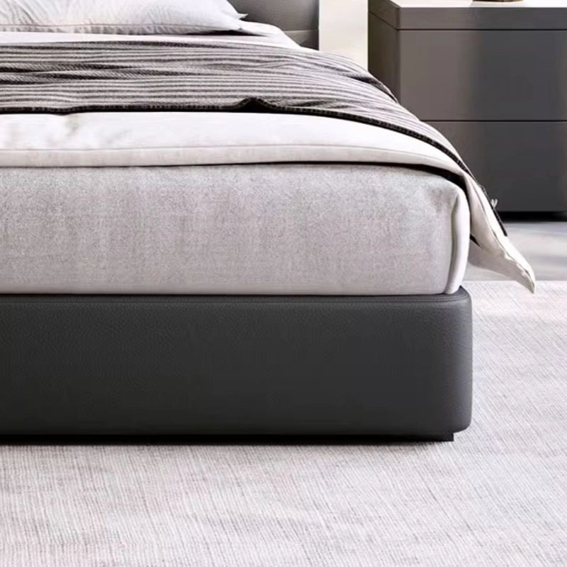 This upholstered bed, ideal for queen mattresses, exemplifies modern minimalism with a bold curved headboard and a sleek black faux leather finish.
