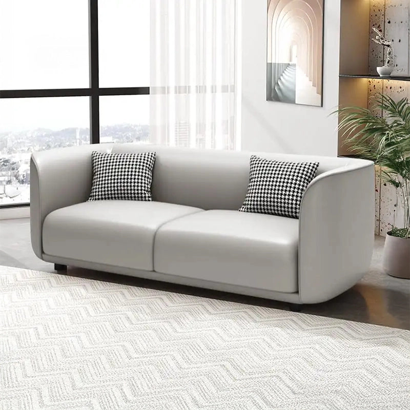 With its integrated low-back design, rounded armrests, and neatly upholstered faux leather surface, it brings comfort to any space without overwhelming it.