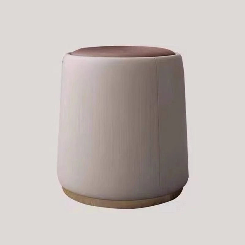 Its minimalist cylindrical form, round seat, and smooth edges offer visual lightness, while the faux leather top in bold colours like green, grey, and orange pairs well with the soft beige body.
