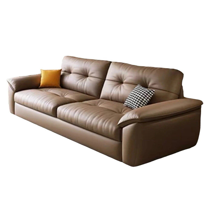 Upholstered in refined leatherette with plush tufted seating and wide padded arms, it offers medium-firm comfort atop a spring-enhanced cushion base
