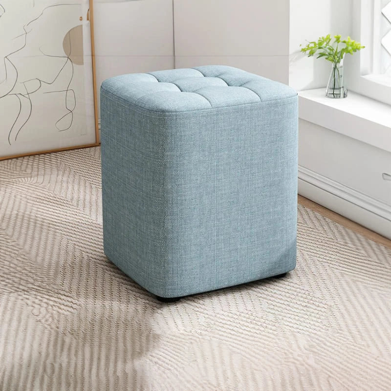 Blue ottoman in a room with a window and plant